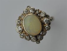 An oval opal and diamond cluster ring in white gol