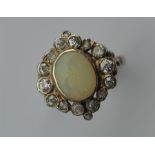 An oval opal and diamond cluster ring in white gol