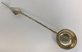 An Eastern ladle with scroll and leaf decoration.