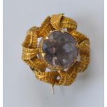 A small gold amethyst circular brooch attractively