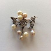 An attractive pearl and diamond brooch in the form