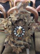 A large carved cuckoo clock together with weights.