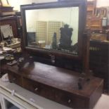 A mahogany bow front toilet mirror.