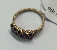 A 9 carat garnet five stone half hoop ring.