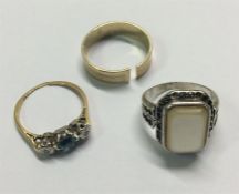 Two gold gem set rings together with a silver ring