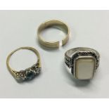 Two gold gem set rings together with a silver ring