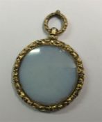An Antique embossed circular pendant with loop top