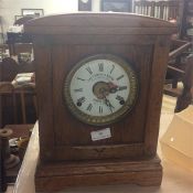 An oak framed mantle clock with white enamel dial.