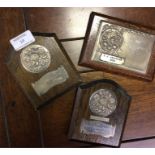 Three silver plaques.