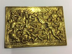 A small brass plaque of a battle scene.