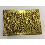 A small brass plaque of a battle scene.