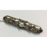 A pearl and yellow stone gold brooch with scroll d