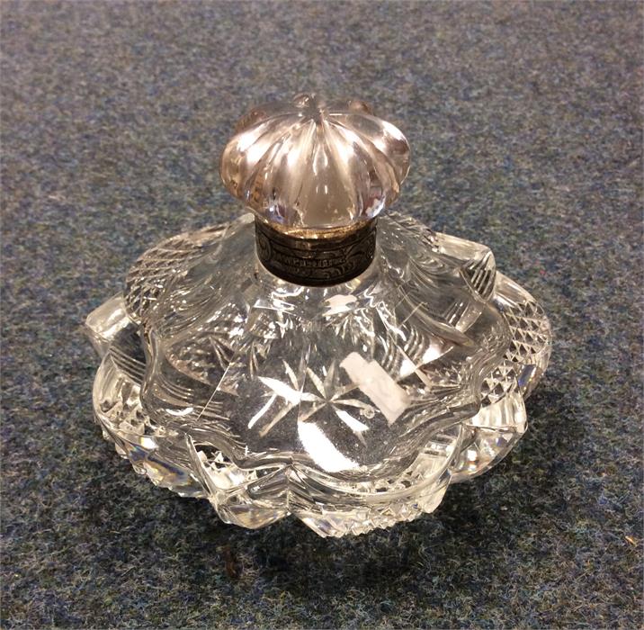 A small silver rimmed scent bottle with cut glass