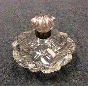 A small silver rimmed scent bottle with cut glass