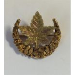 A 14 carat crescent brooch mounted with a Canadian