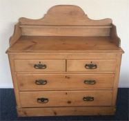 A stripped pine chest of four drawers on pedestal