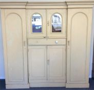 A painted pine triple wardrobe with cupboard to ba