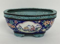 An Oriental cloisonné bowl decorated with figures.