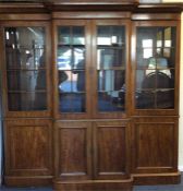 A large mahogany four door break front bookcase on