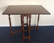 A mahogany drop leaf table on slender turned suppo