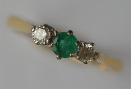 An 18 carat emerald and diamond three stone ring i