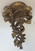 A small gilt wood bracket decorated with scrolls a