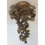 A small gilt wood bracket decorated with scrolls a