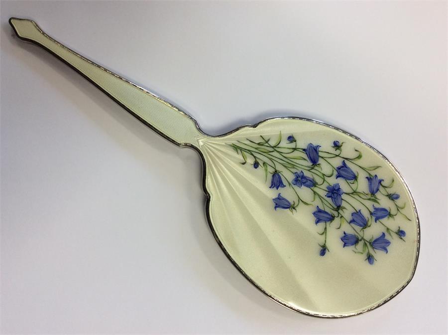 An enamelled hand mirror decorated with flowers. B