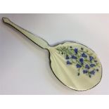 An enamelled hand mirror decorated with flowers. B
