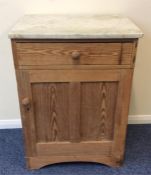 A stripped pine single door cupboard with marble t