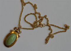A small gold pendant with ribbon decoration on fin