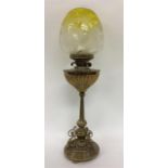 A brass mounted oil lamp with yellow glass shade.