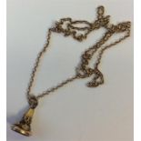 A small gold seal with loop top on fine link chain