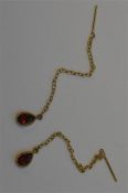 A pair of small garnet teardrop earrings on fine l