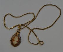 A 9 carat cameo pendant on fine link chain. Approx