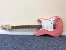 A Johnson electric six string guitar in pink. Est.