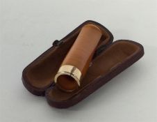 A small amber cigar holder contained within a leat