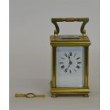 A small brass carriage clock with white enamelled