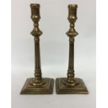 A good pair of Antique brass candlesticks on squar