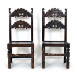 A pair of 18th century oak Derbyshire hall chairs with solid seats on turned supports joined by