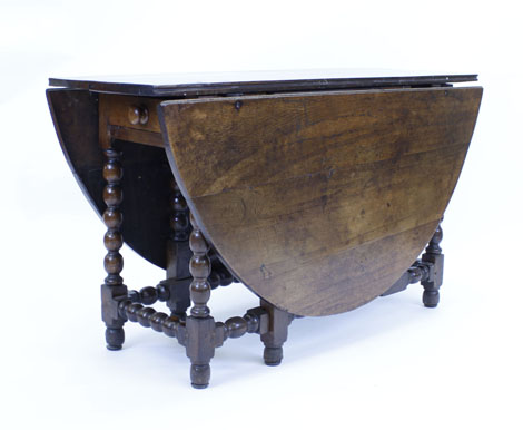 An 18th century and later oak gateleg dining table with a single frieze drawer on bobbin turned
