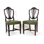 A pair of Hepplewhite-type mahogany and green leather dining chairs on tapering legs