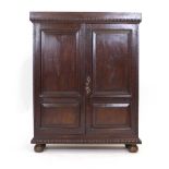 An 18th century oak cupboard, the two panelled doors enclosing shelves, on bun feet, w.