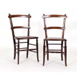 A pair of early 20th century stained beech side chairs with solid seats over bergere on turned legs