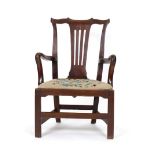 An 18th century mahogany open armchair on square straight feet