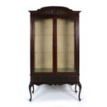 An early 20th century mahogany and glazed two door display cabinet on cabriole feet, w.