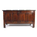 An 18th century oak coffer with panelled lid, sides an front on square straight stiles, w.