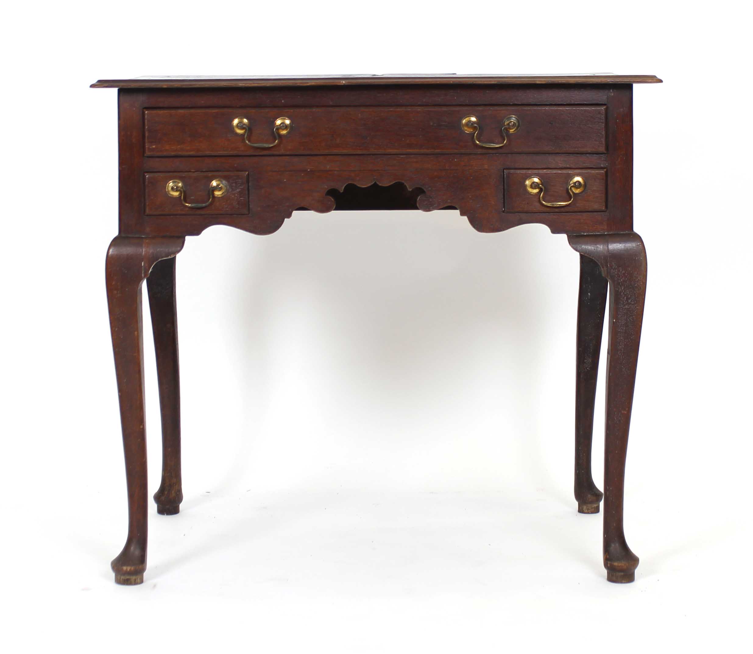 An 18th century oak lowboy with an arrangement of three drawers over a shaped apron on cabriole