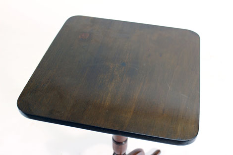 An 18th century mahogany square and tilt-top occasional table on a turned column and three splayed - Image 2 of 2