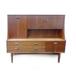 A 1970's teak highboard with an arrangement of three doors, two drawers and a fall front, l.